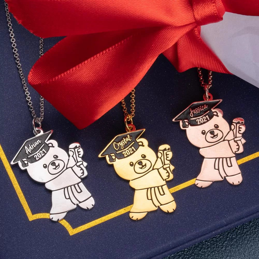 Three custom graduation bear necklaces in silver, gold, and rose gold with personalized engraving