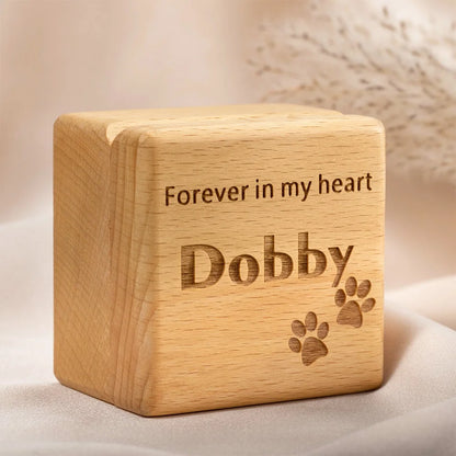 Wooden cube with engraved text 'Forever in my heart Dobby' on a soft background