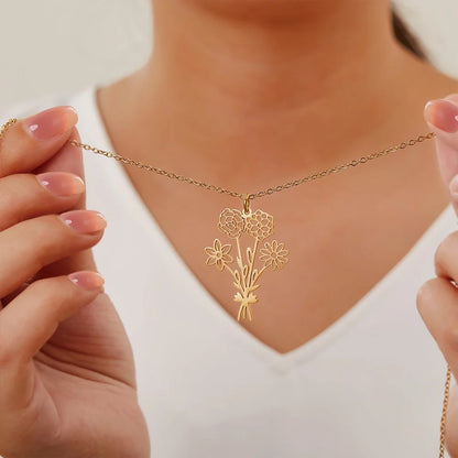 Gold necklace with custom bouquet floral pendant held by a person wearing a white top.