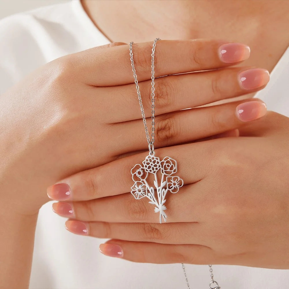 Silver Bouque tof birth flower necklace held between hands against a white background