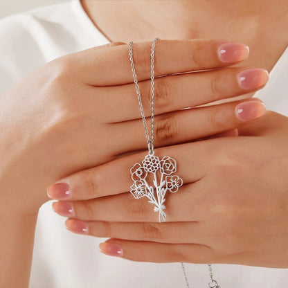 Silver Bouque tof birth flower necklace held between hands against a white background