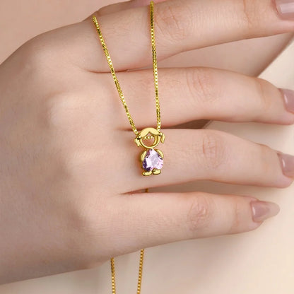Minimalist gold girl charm with birthstone necklace worn on hand, new mom gift idea