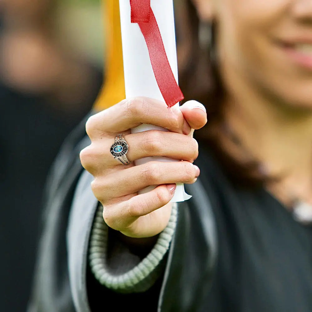 Woman holding diploma wearing personalized college class ring with birthstone