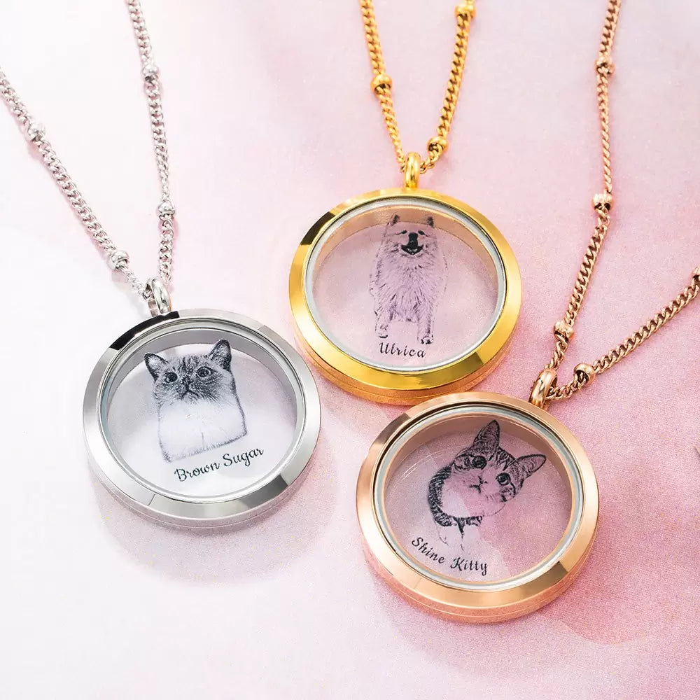 A collection of custom pet fur locket urn necklaces with various designs, including cats and a dog, each with a personalized engraving of the pet's photo and name.