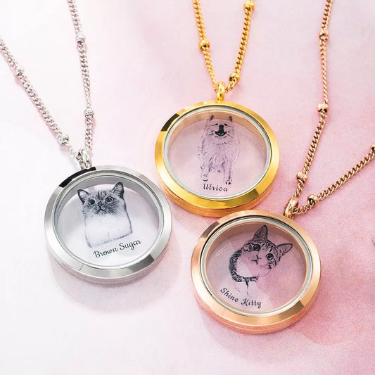 A collection of custom pet fur locket urn necklaces with various designs, including cats and a dog, each with a personalized engraving of the pet's photo and name.