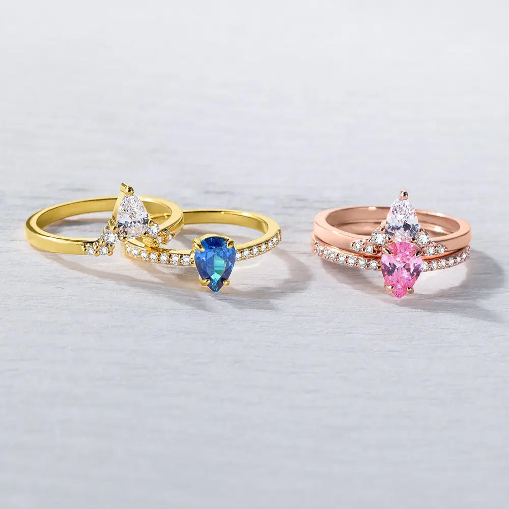 Gold and rose gold double birthstone rings displayed side by side, showing different stone color combinations