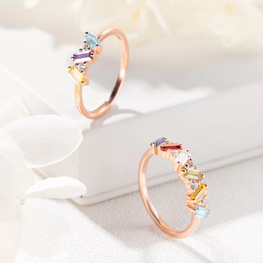 Rose gold personalized baguette birthstone ring displayed on a white jewelry box