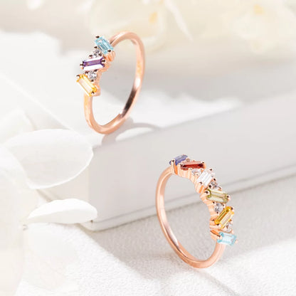 Rose gold personalized baguette birthstone ring displayed on a white jewelry box