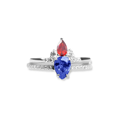 Close-up of a silver double birthstone ring with two pear-shaped stones and small accent crystals