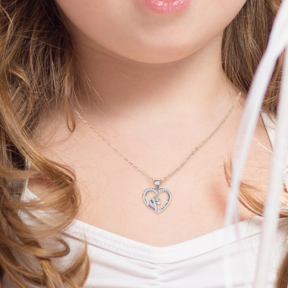A girl is wearing a cute  silver  unicorn heart shaped necklace