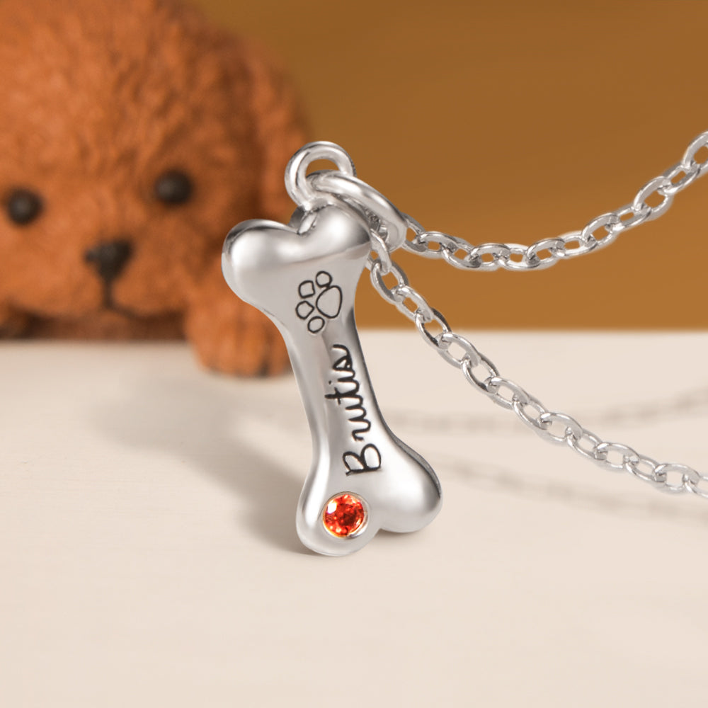 A Custom silver dog  bone pendant with birthstone and dog name engraved 
