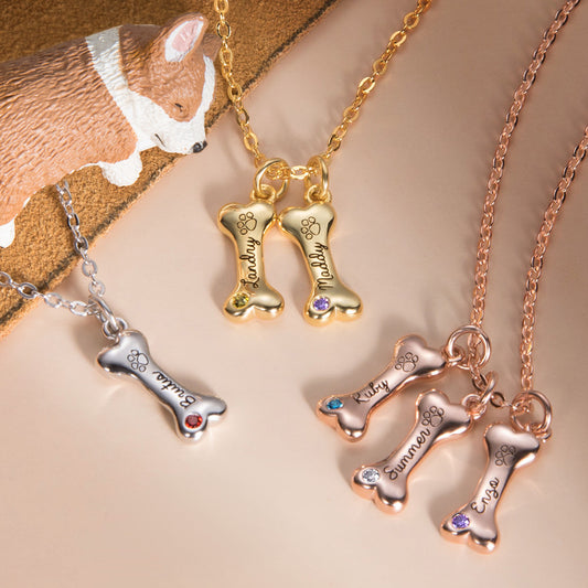 A display of three style of necklace. One is silver cute dog bone pendant with dog name engraved , one with two cute gold bone pendant with two dog name engraved . The other is three  custom red rose bone pendant with three dog name engraved on each.  